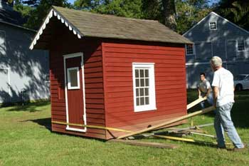 People moving a small building